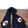 Black chiffon hijab featuring circular fabric floral appliques in maroon, cream, and brown at the ends.