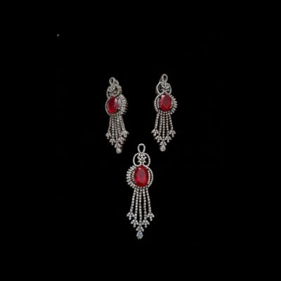 Complete jewelry set including a matching ruby pendant and drop earrings with a chandelier design and teardrop diamond accents.