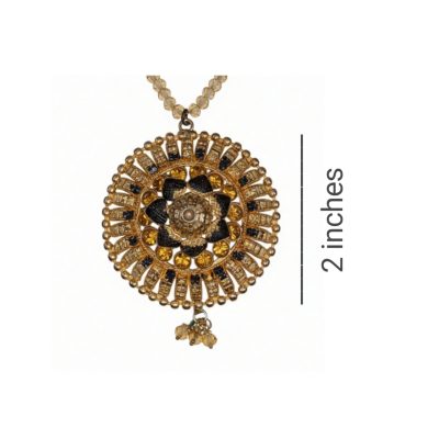 A close-up of a 2-inch circular antique gold-finished mandala pendant featuring intricate filigree, black enamel accents, and amber-colored glass stones on a crystal bead chain.