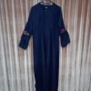 Full-length view of a simple black abaya with long sleeves and delicate floral applique accents.