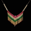 V-shaped fringe statement necklace crafted with rows of red, emerald green, and clear stones on a deep black background.